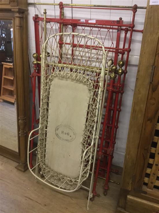 Red painted metal bed and a folding white painted cot